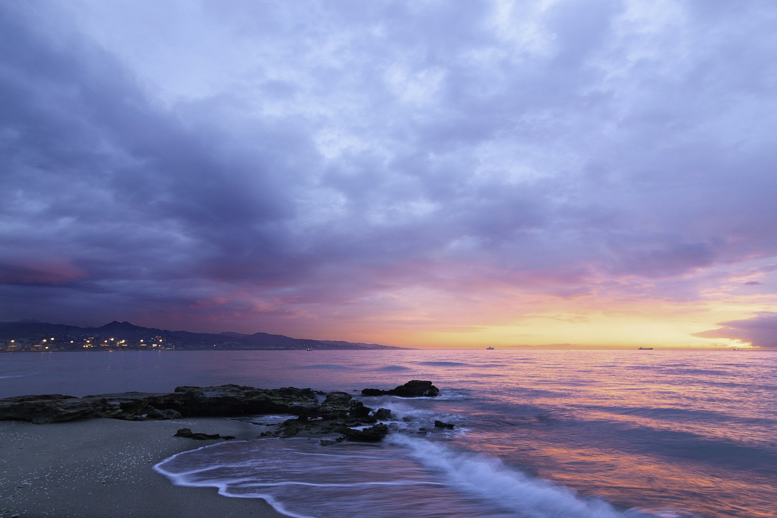 Cielo rosado y azul reflejado en el mar al atardecer